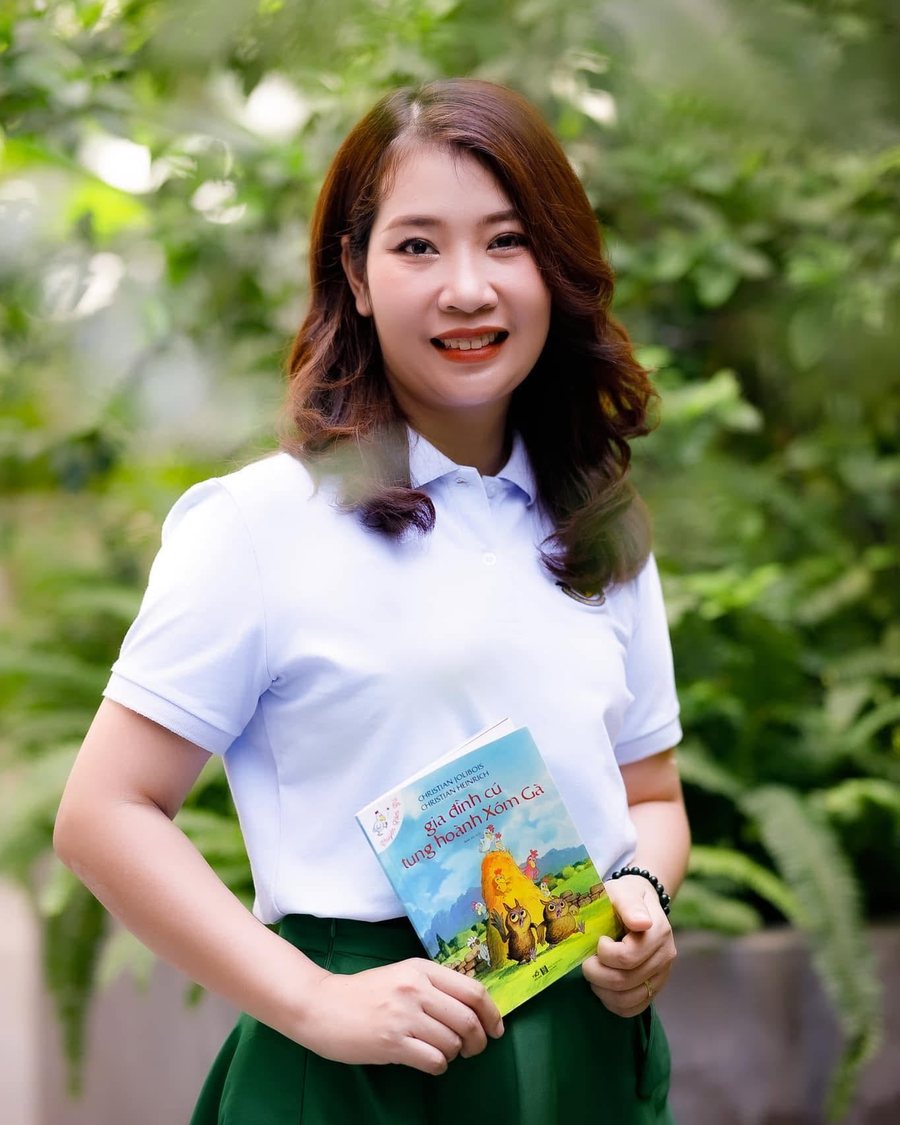 Cô Nguyên Lý cầm một cuốn sách của mình